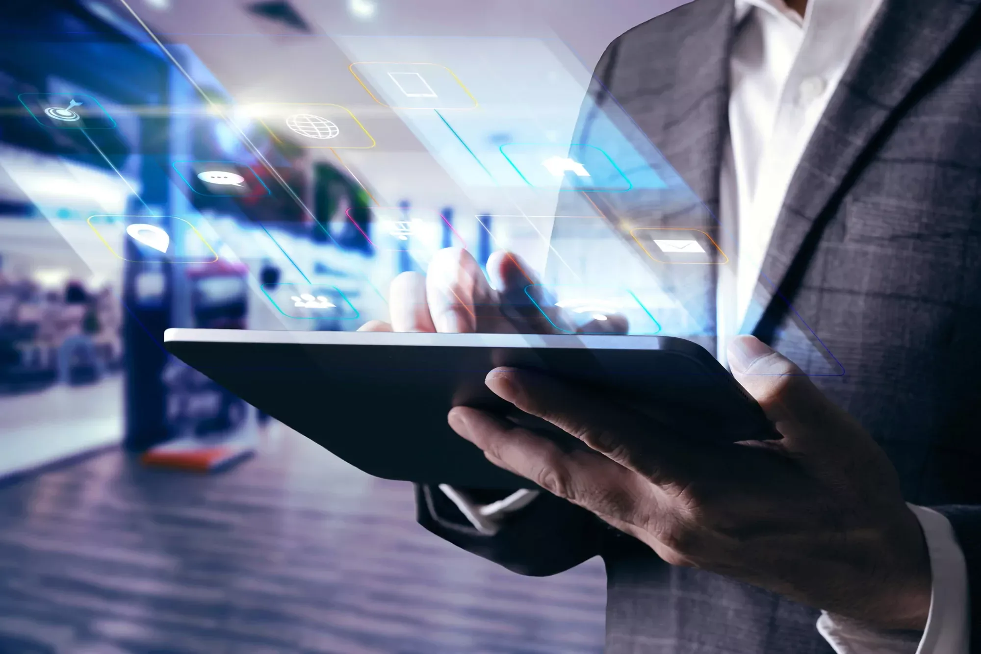 Business professional in suit holding tablet with glowing digital interface and icons.